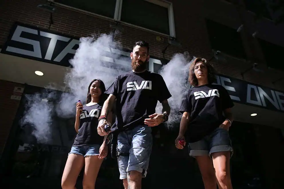 Vape shop Street Vape One con clientes fumando vaporizadores en la calle.